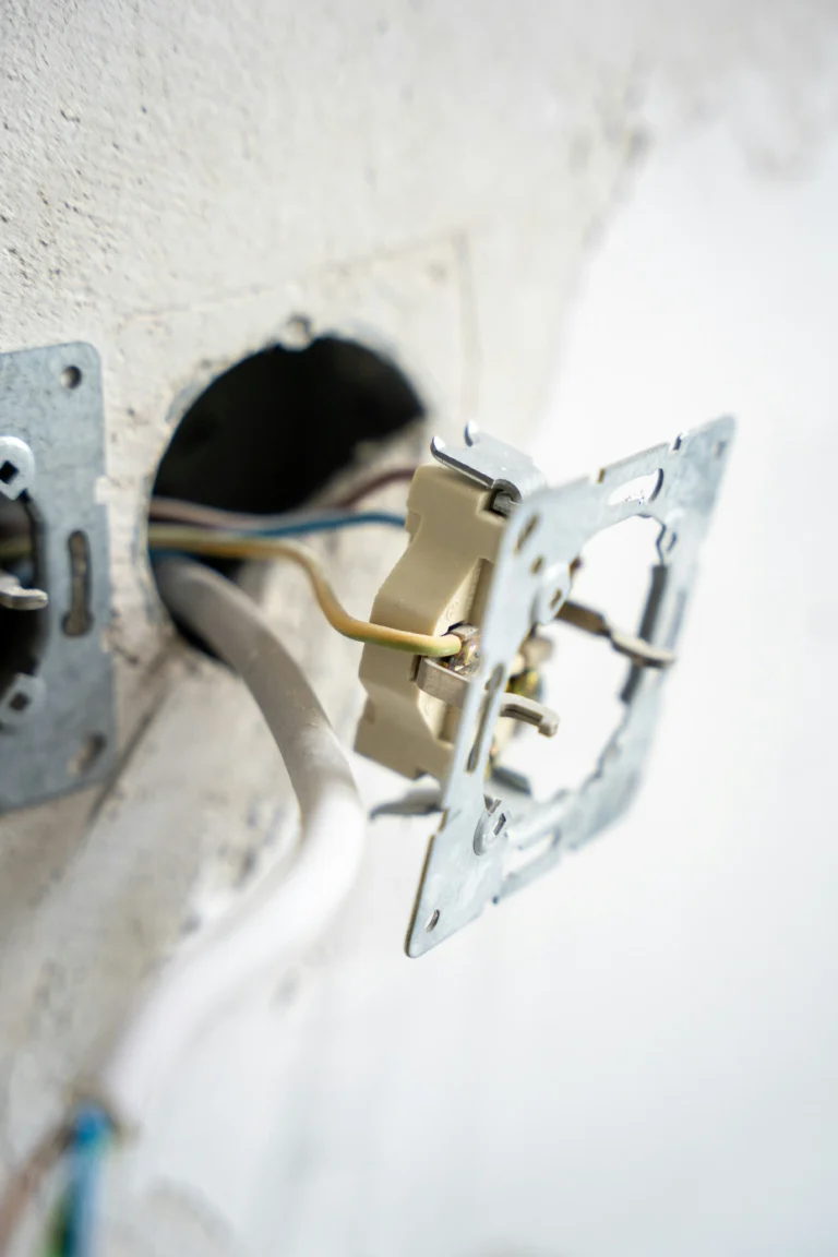 Electrician working on electrical wiring and a wall outlet